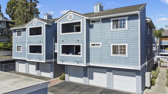 Front view of a multi-story residential building with multiple garages.