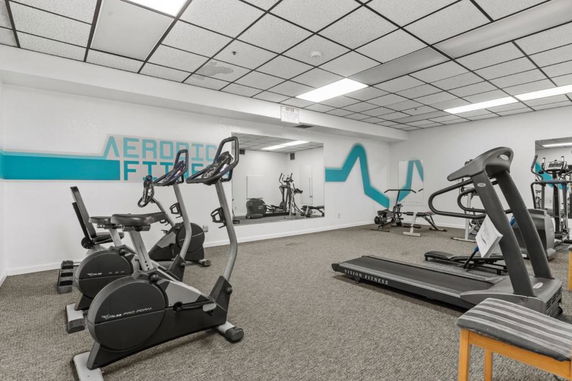 Indoor gym area with exercise bikes, treadmill, and fitness equipment.
