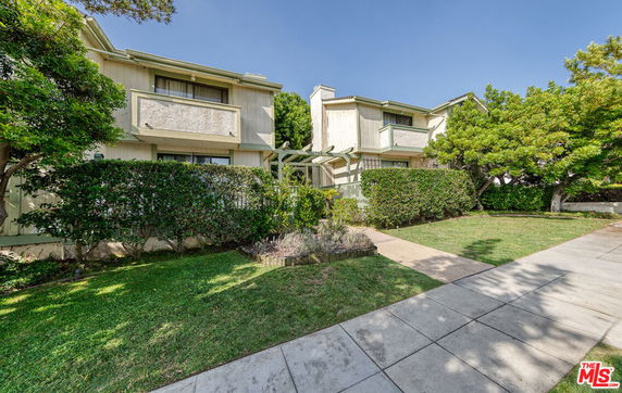 Front view of a two-story residential building with a landscaped garden.