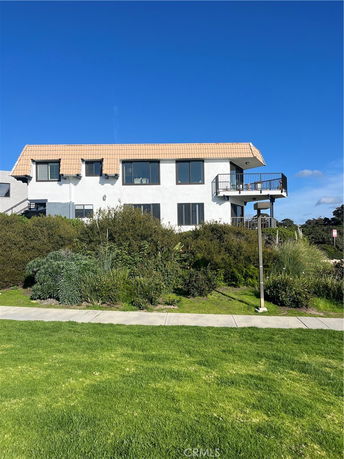 Front view of a two-story house with a tiled roof and multiple windows.