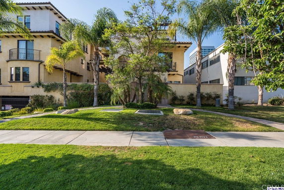 Front view of a multi-story building with balconies and Mediterranean-style architecture.