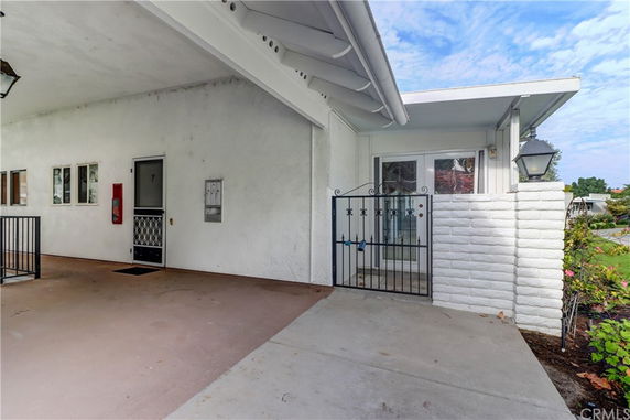 Front view of a house with a covered entryway and a gated entrance.