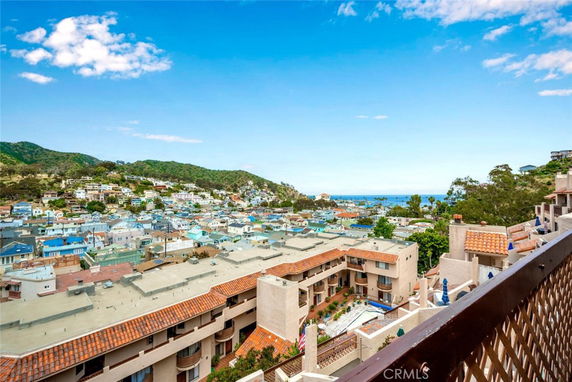 Panoramic view of a residential area with hills and ocean in the distance.