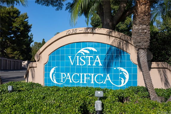 Entrance sign with 'Vista Pacifica' written on it, surrounded by trees and greenery.
