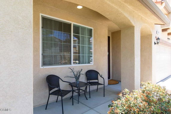 Front view of a house with a porch and seating area.