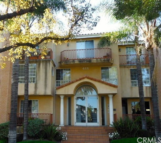 Front view of a three-story building with balconies and columns.