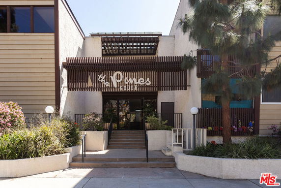 Front view of a building entrance with steps and decorative wooden paneling.