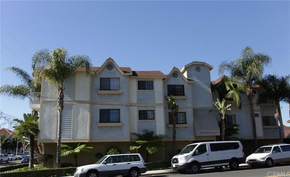 Front view of a multi-story building with palm trees.