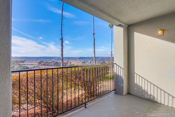 Outdoor view from a balcony with railings overlooking a scenic landscape.