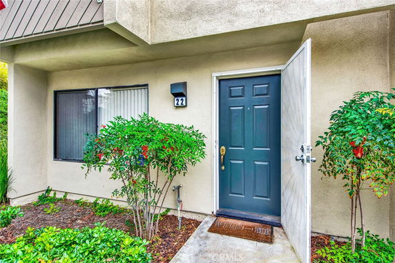 Front view of a house with a dark blue door and a small window next to it.