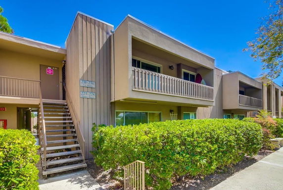 Front view of a multi-unit residential building with balconies and exterior stairs.
