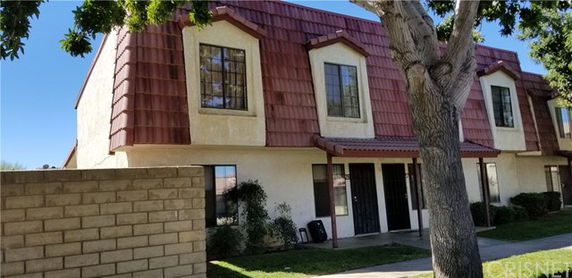 Front view of a two-story building with red-tiled roof and multiple windows.