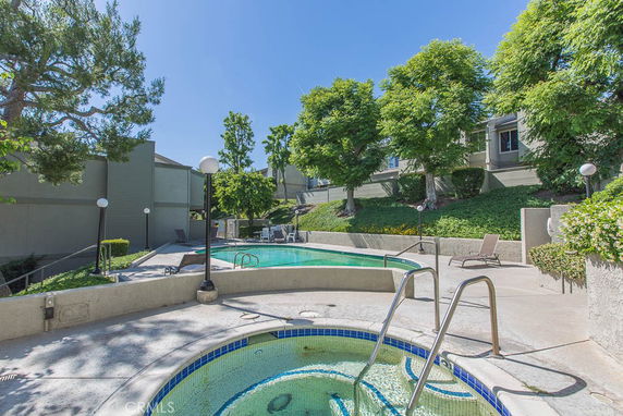 Outdoor swimming pool area with surrounding greenery.