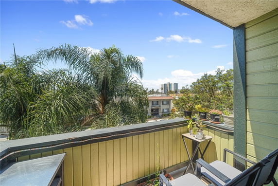 Balcony view overlooking trees and distant buildings.