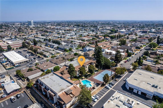 Aerial view of a suburban area with residential buildings, swimming pool, and tennis court.