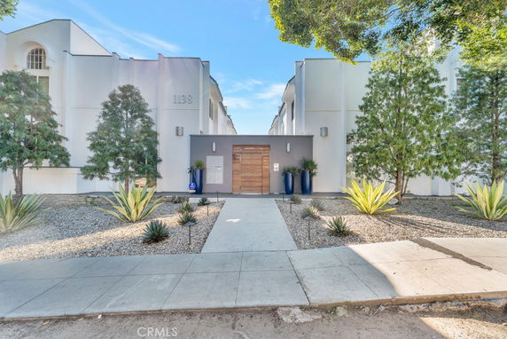 Front view of a modern building with a central entrance and minimalistic landscaping.