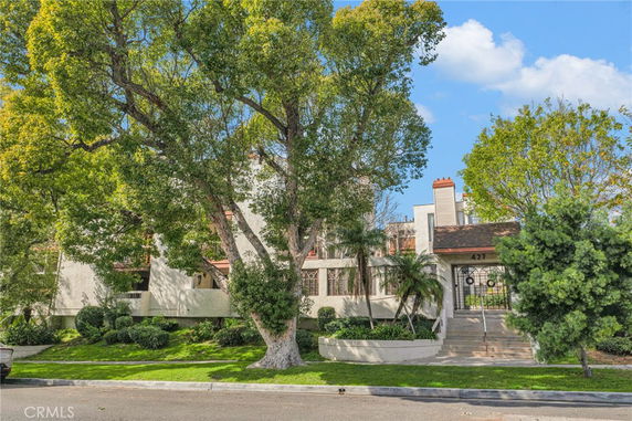 Front view of a multi-story building with trees and greenery.