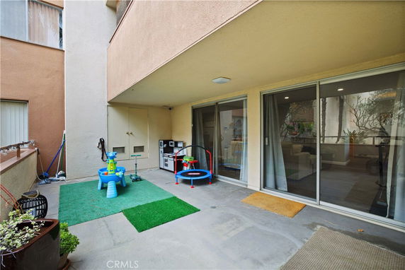 Indoor play area with children's toys and sliding glass doors.