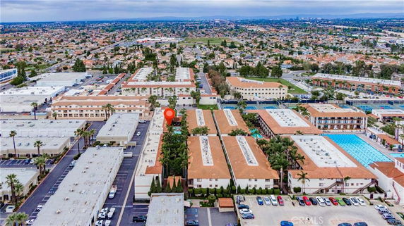 Aerial view of a residential complex with multiple buildings and a large swimming pool.