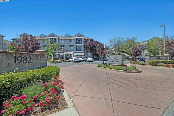 Front view of a multi-story residential building with entrance driveway.