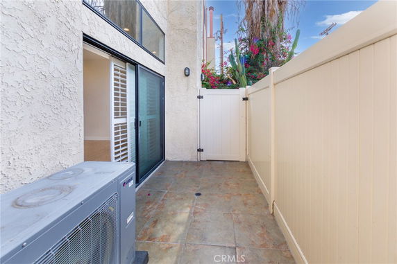 Outdoor area with a sliding glass door and air conditioning unit.