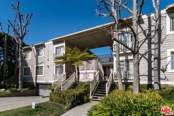 Front view of a two-story building with shingle siding and central staircase.