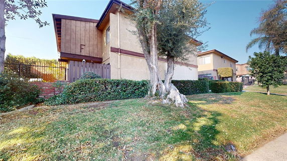 Side view of a two-story house with brick and wood exterior.