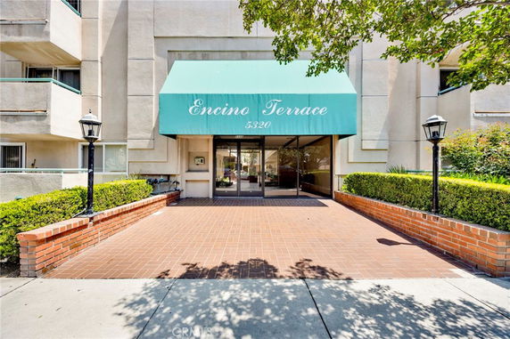 Front view of a building with a green awning over the entrance labeled Encino Terrace.