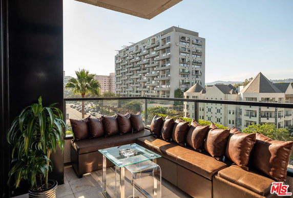 Panoramic view from a balcony overlooking a cityscape with buildings.