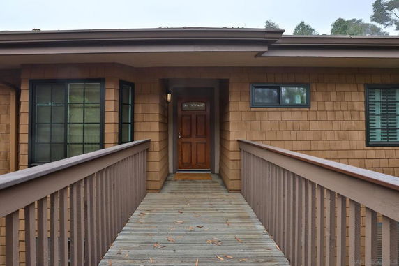 Front view of a house with a wooden walkway leading to the entrance.