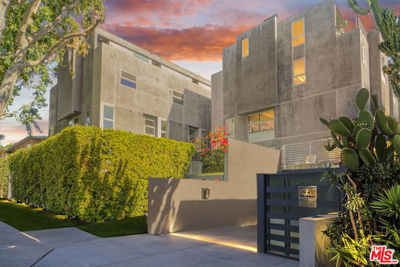 Front view of a modern multi-story building with a gated entrance.