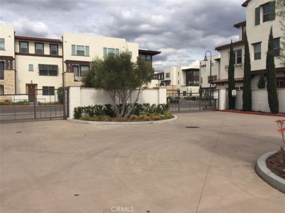 Front view of multi-story residential buildings with a paved driveway.