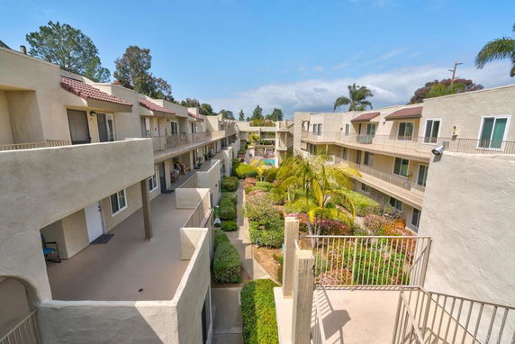 View of apartment complex courtyard with balconies and landscaping.