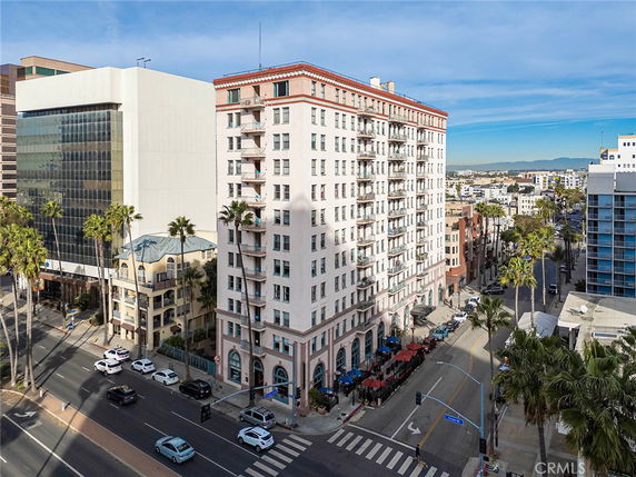 Front view of a multi-story building situated at the corner of a busy intersection.