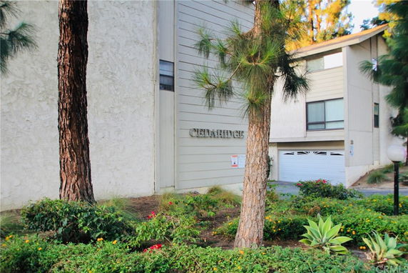 Front view of a multi-story building with a garage and trees in the surrounding area.