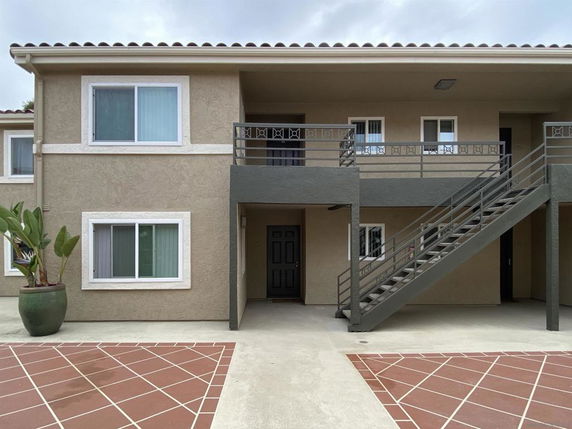 Front view of a two-story building with external staircase.