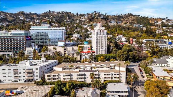 Aerial view of urban buildings with hills in the background.