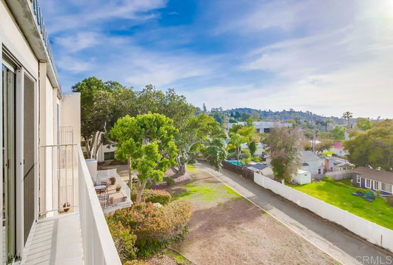 Wide view of the surrounding areas with greenery and houses from a balcony perspective.