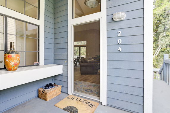 Front view of a house with a blue exterior and a glass door entry.