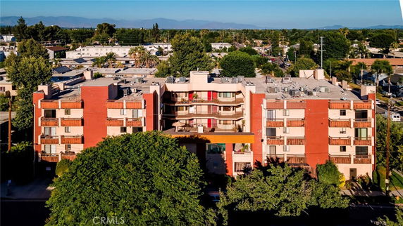 Front view of a multistory apartment building with red and beige exterior.