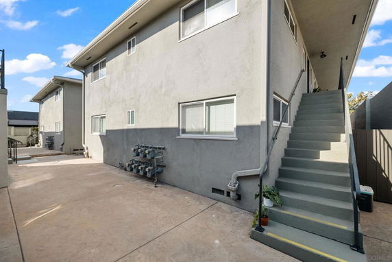 Side view of a two-story apartment building with exterior staircase.