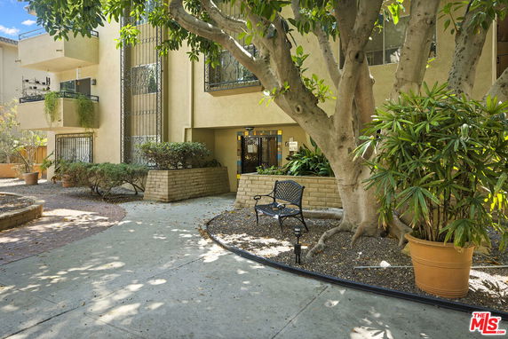 Front view of a residential building entrance with a pathway and garden area.