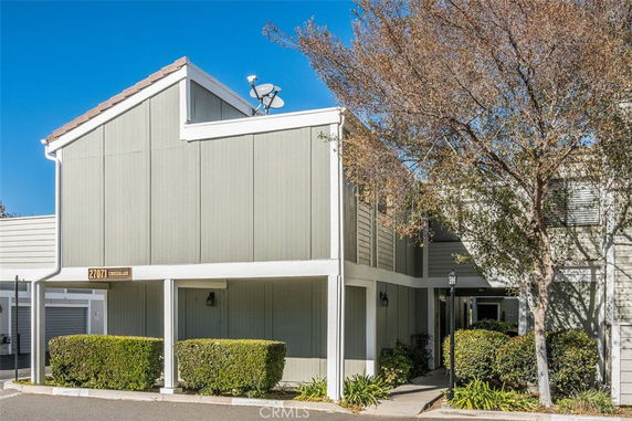Front view of a two-story house with a flat roof and satellite dish.