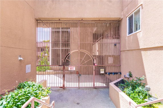 Front view of a building entrance with a metal gate and planters.