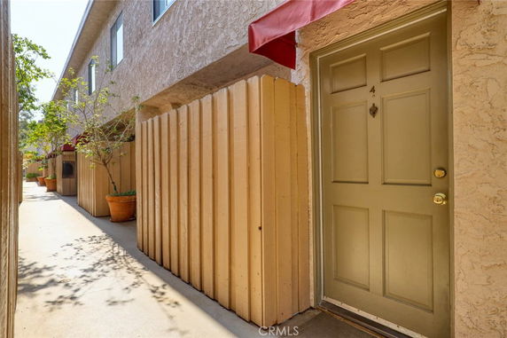 Front view of a two-story building with adjacent entrance door and awning.