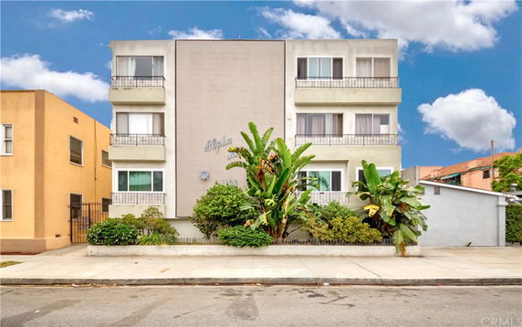 Front view of a three-story apartment building with balconies.