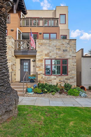 Front view of a multi-story house with stone and wood exterior.