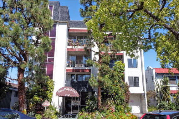 Front view of a multi-story apartment building with balconies.