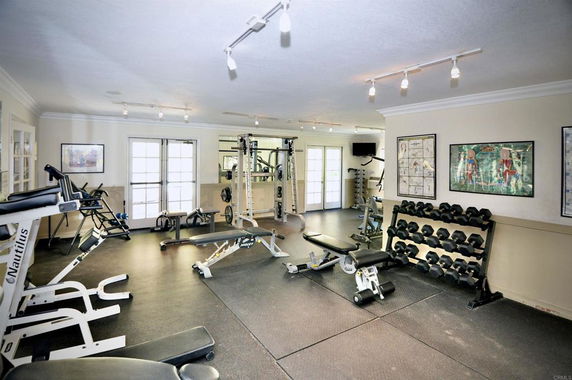 Interior view of a gym with various exercise equipment and weights.