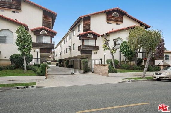 Front view of a multi-story residential building with gated entrance.